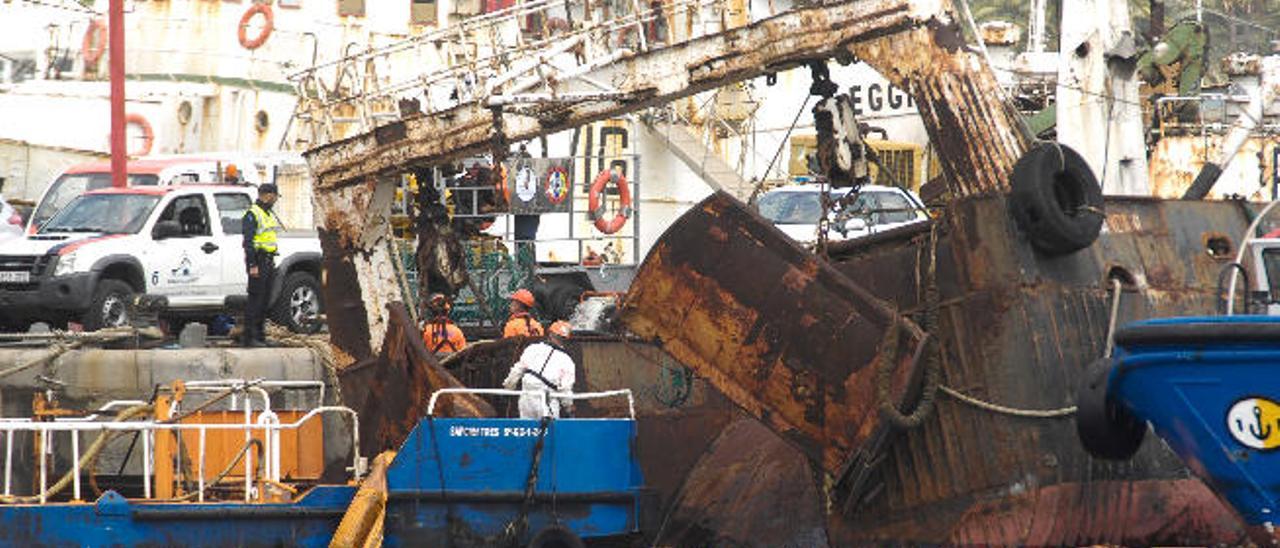 Operarios de la empresa Sepcan intervienen, ayer, para impedir el hundimiento del barco