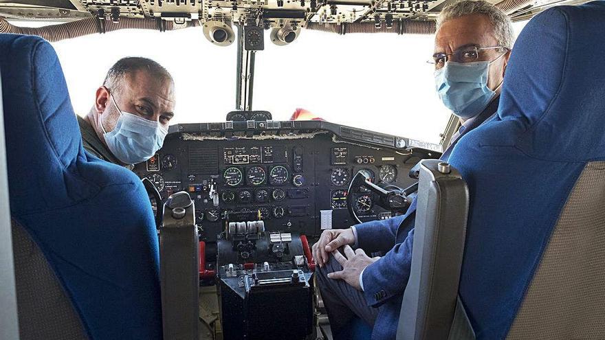 Javier Izquierdo (derecha) visita uno de los aviones antiincendios del ministerio.