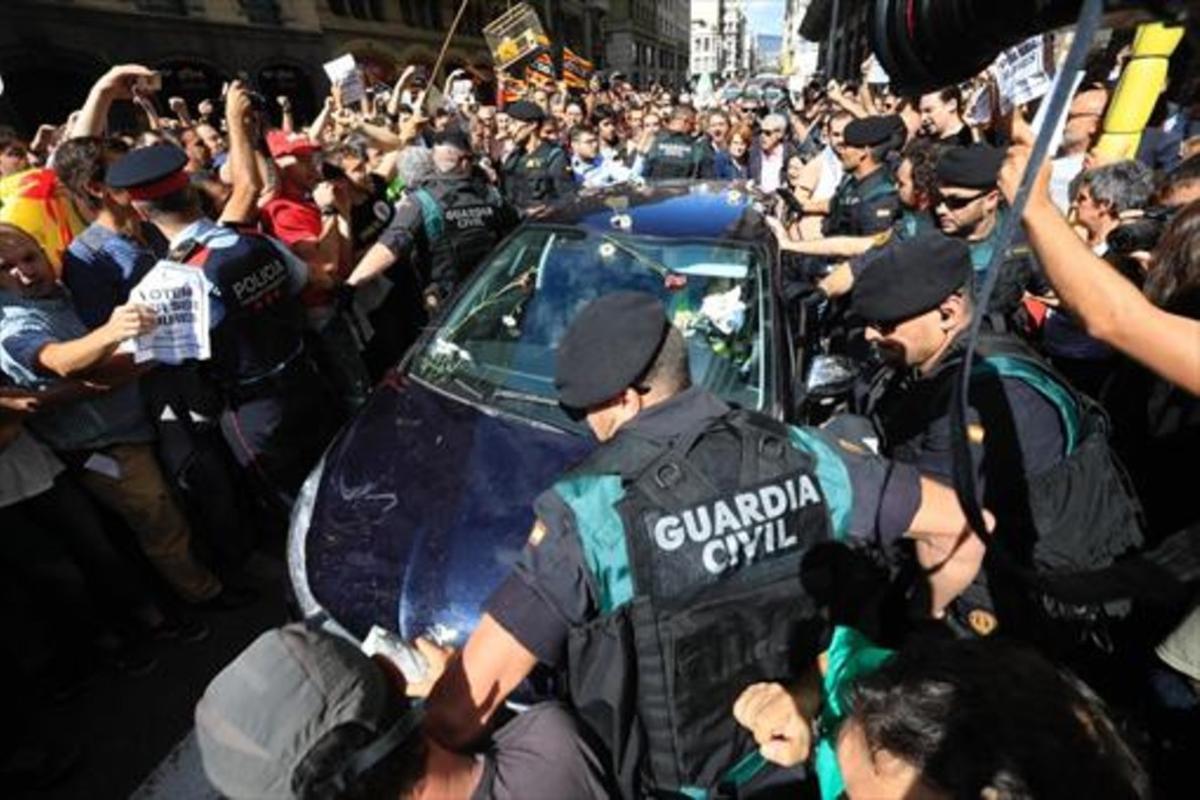 Mossos ayudan a guardias civiles a salir de una concentración de protesta ante la Conselleria d’Afers Exteriors. Mossos ayudan a guardias civiles a salir de una concentración de protesta ante la Conselleria d’Afers Exteriors.