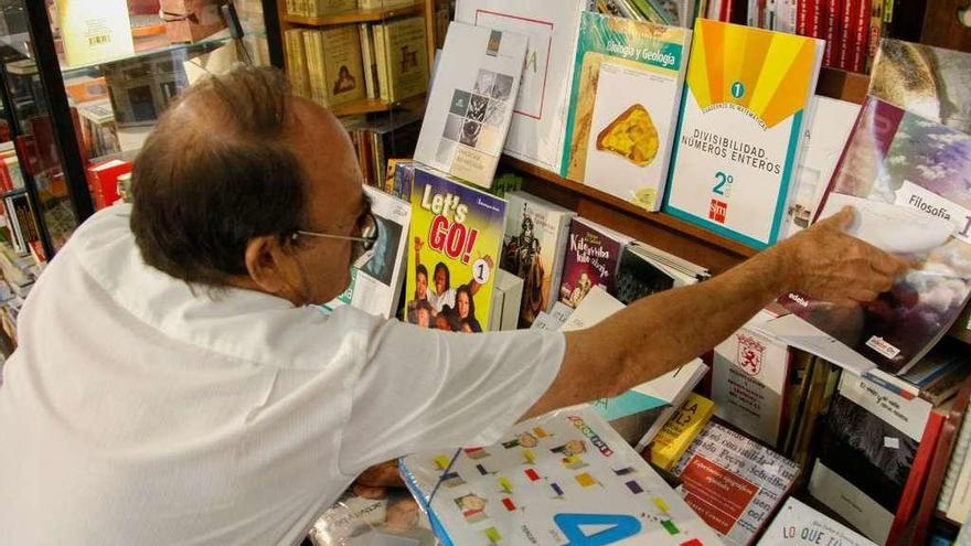 Luis González, propietario de la librería Semuret, ordenando varios libros de texto.