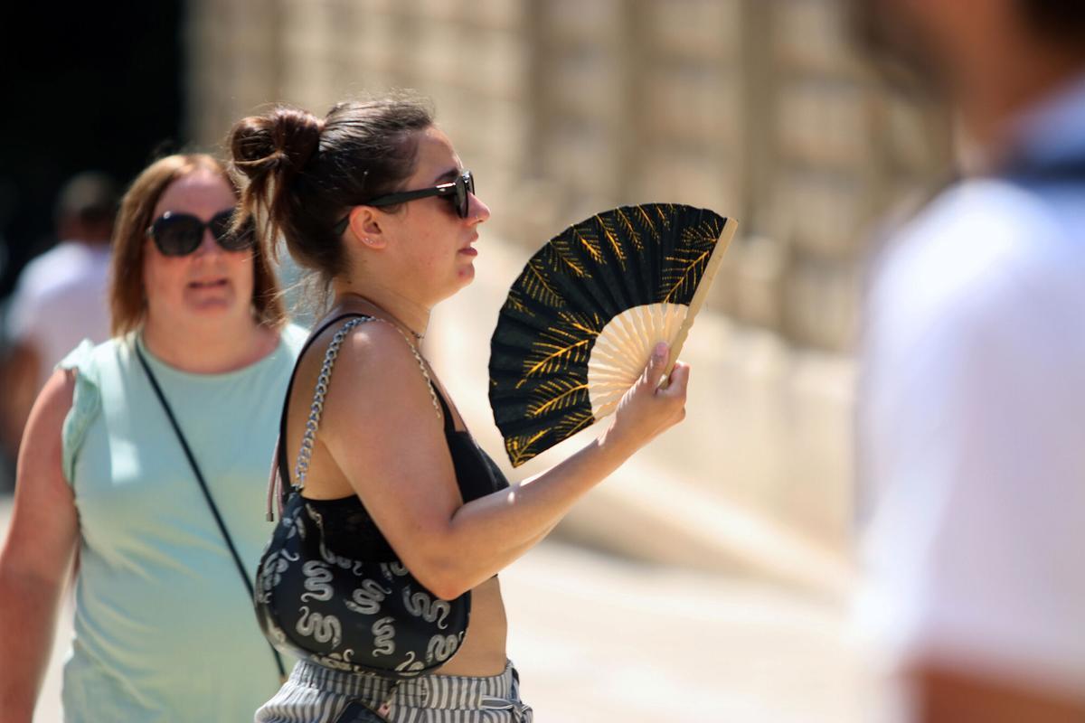 Calor. Viandantes soportan las altas temperaturas por las calles de Málaga