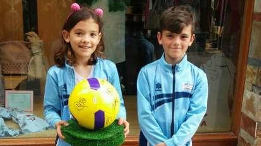 Paula y Juanjo Costales, con el balón firmado por los jugadores del Sporting.