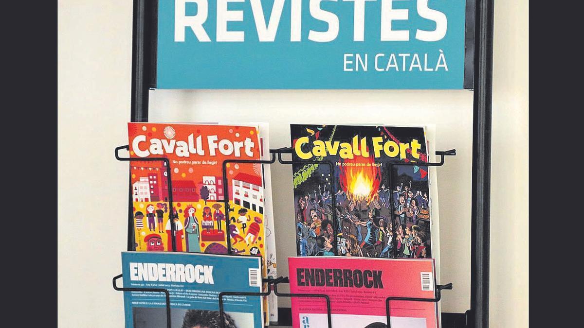 Exemplars de les revistes «Cavall Fort» i «Enderrock» en un expositor de llibreria.