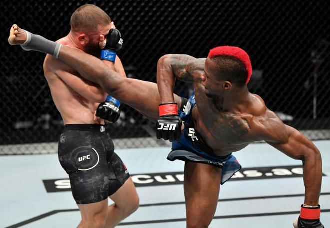 Marc Diakiese de la República Democrática del Congo (D) pateando a Rafael Fiziev de Kazajstán, en su lucha por el campeonato de peso pluma durante el evento UFC 251 en la Isla de la Lucha de la UFC en la Isla Yas de Abu Dhabi.