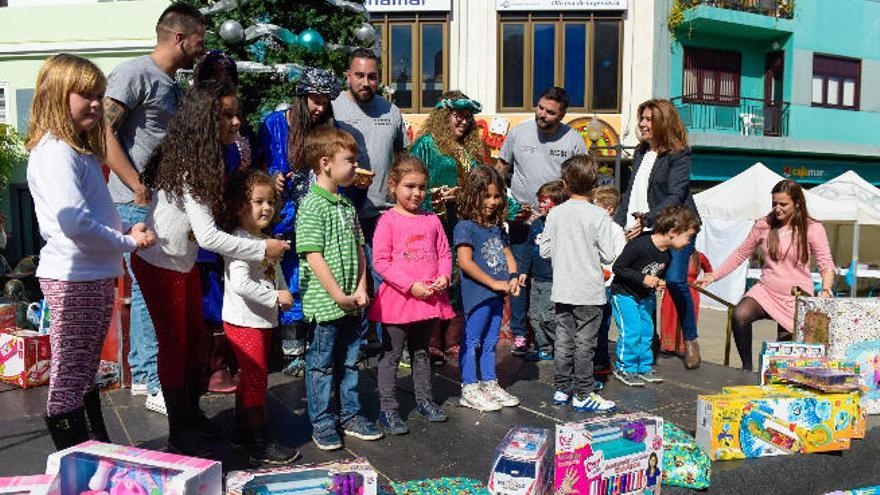 Niños, colaboradores y la alcaldesa, durante la recogida solidaria de juguetes, ayer, en San Gregorio.