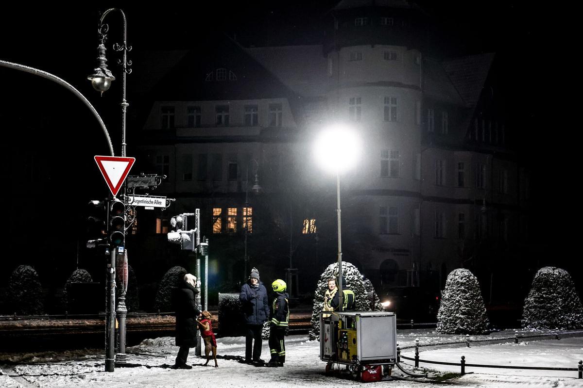 Un equipo de bomberos asiste a vecinos berlineses en la plaza Mexikoplatz en pleno apagón, este sábado.