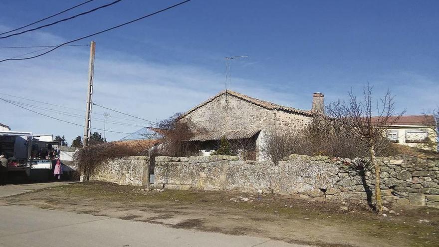 Edificio de la casa parroquial rodeado por una cerca de piedra, cuya venta ha sido anunciada por el Obispado.