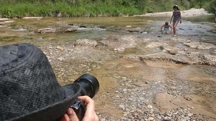 Banyistes gaudint de l&#039;entorn de la Ribera Salada i un participant d&#039;un taller d&#039;imatges a l&#039;espai, fotografiant-los