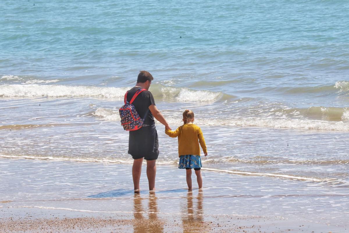 Las buenas temperaturas animan a algunos a mojarse los pies en las playas de Torrevieja