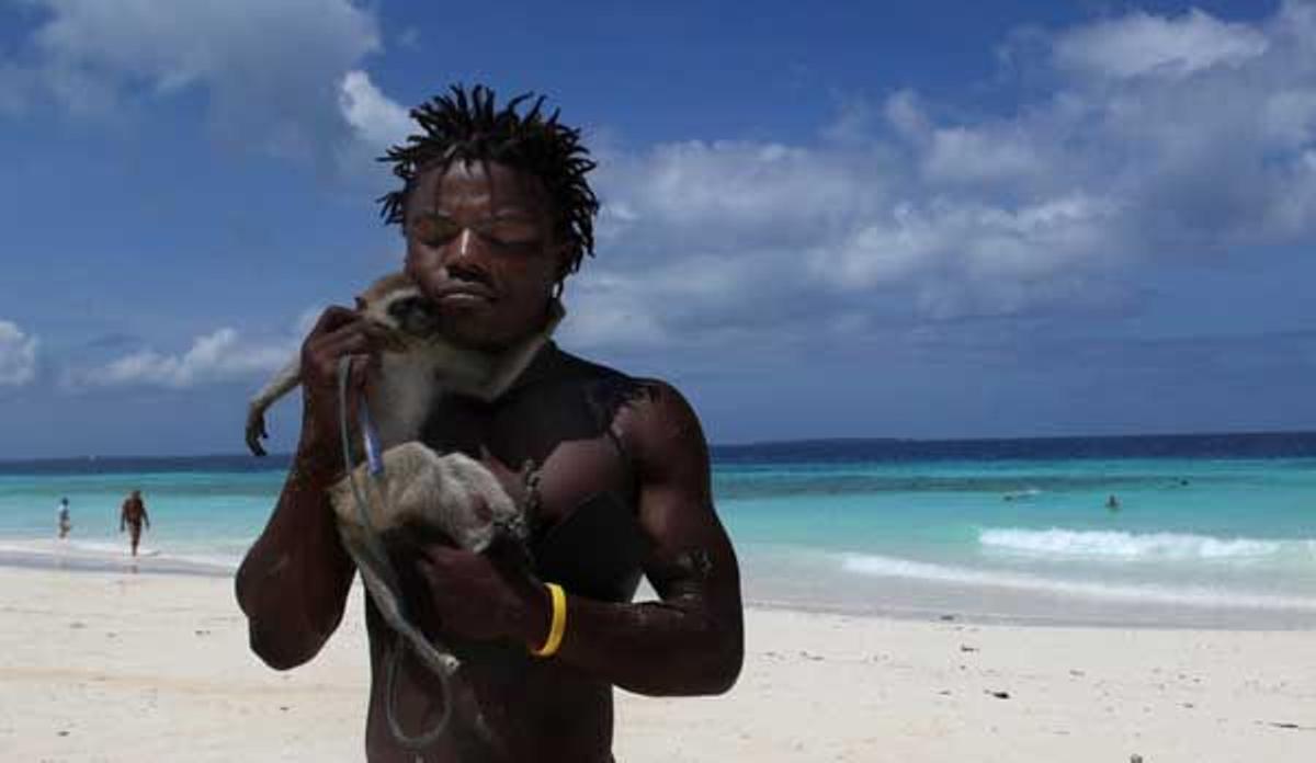 Un chico con su mascota, un mono, en la playa de Nungwi, al norte de la isla.
