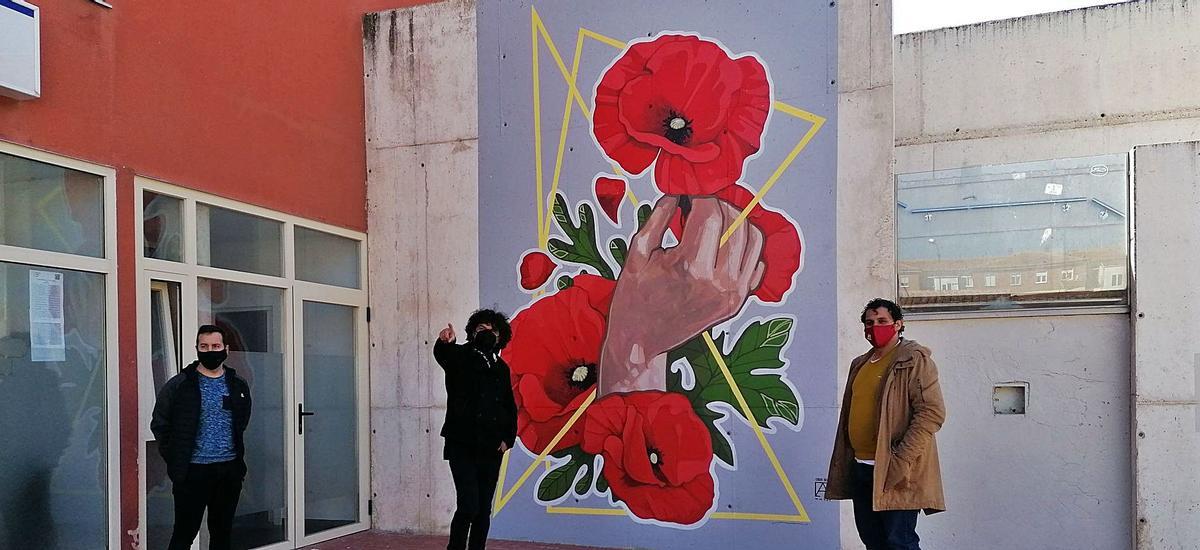 De izquierda a derecha, Álvarez, Adeva y Del Bien posan con el nuevo mural del centro de salud creado en homenaje a las víctimas del COVID. | M. J. C.