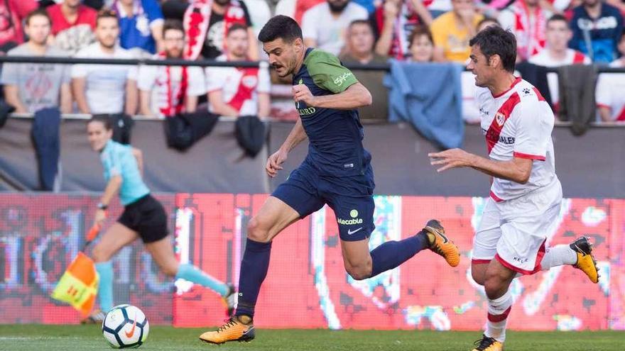 Sergio conduce el balón presionado por un rival.