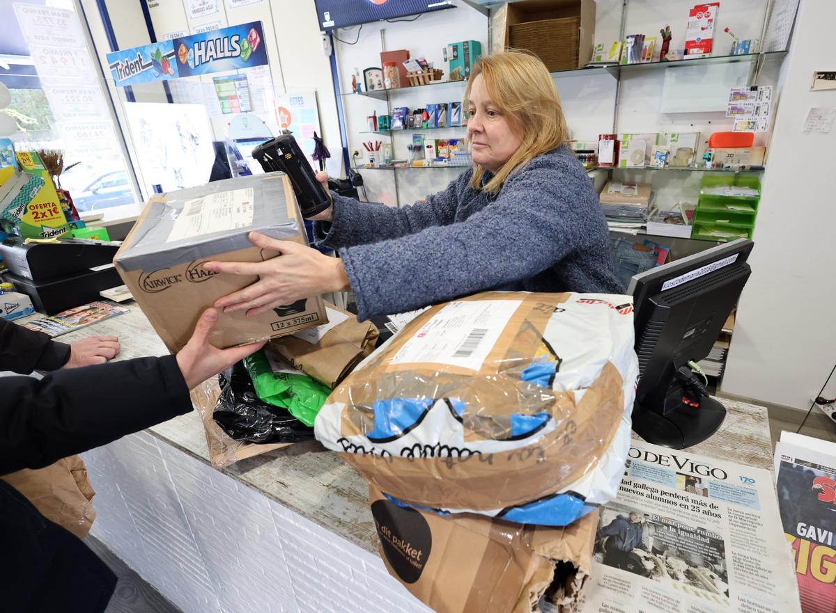 María Pérez registra varios paquetes en su kiosco, situado en Vigo, ayer.