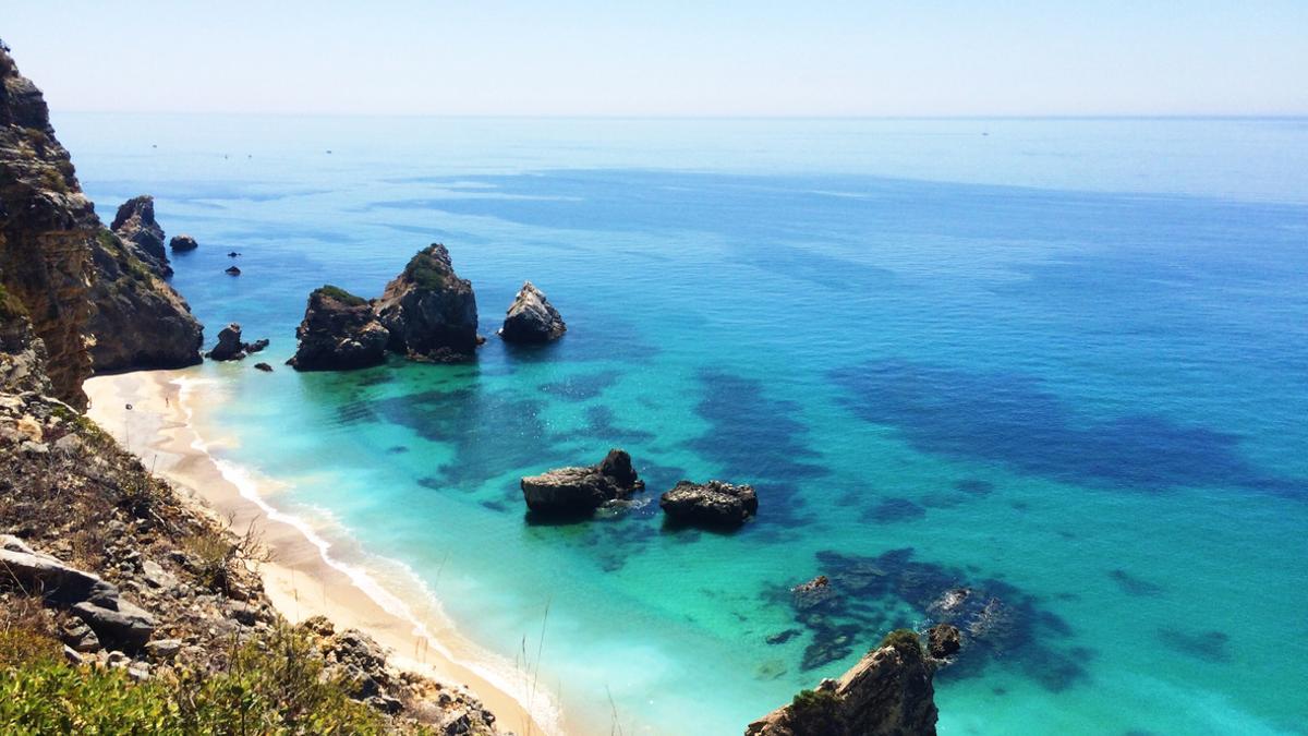 Praia do Ribeiro do Cavalo rodeada de acantilados y con aguas cristalinas