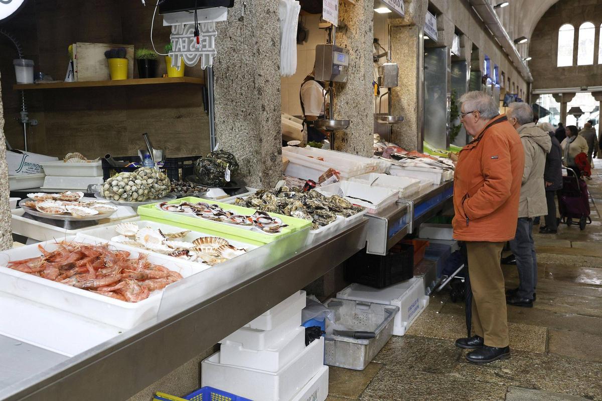 Un hombre ojea uno de los puestos de pescado del Mercado de Abastos de Santiago