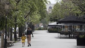 Una mujer camina con su hija por una Rambla de Catalunya desierta, el 23 de abril.