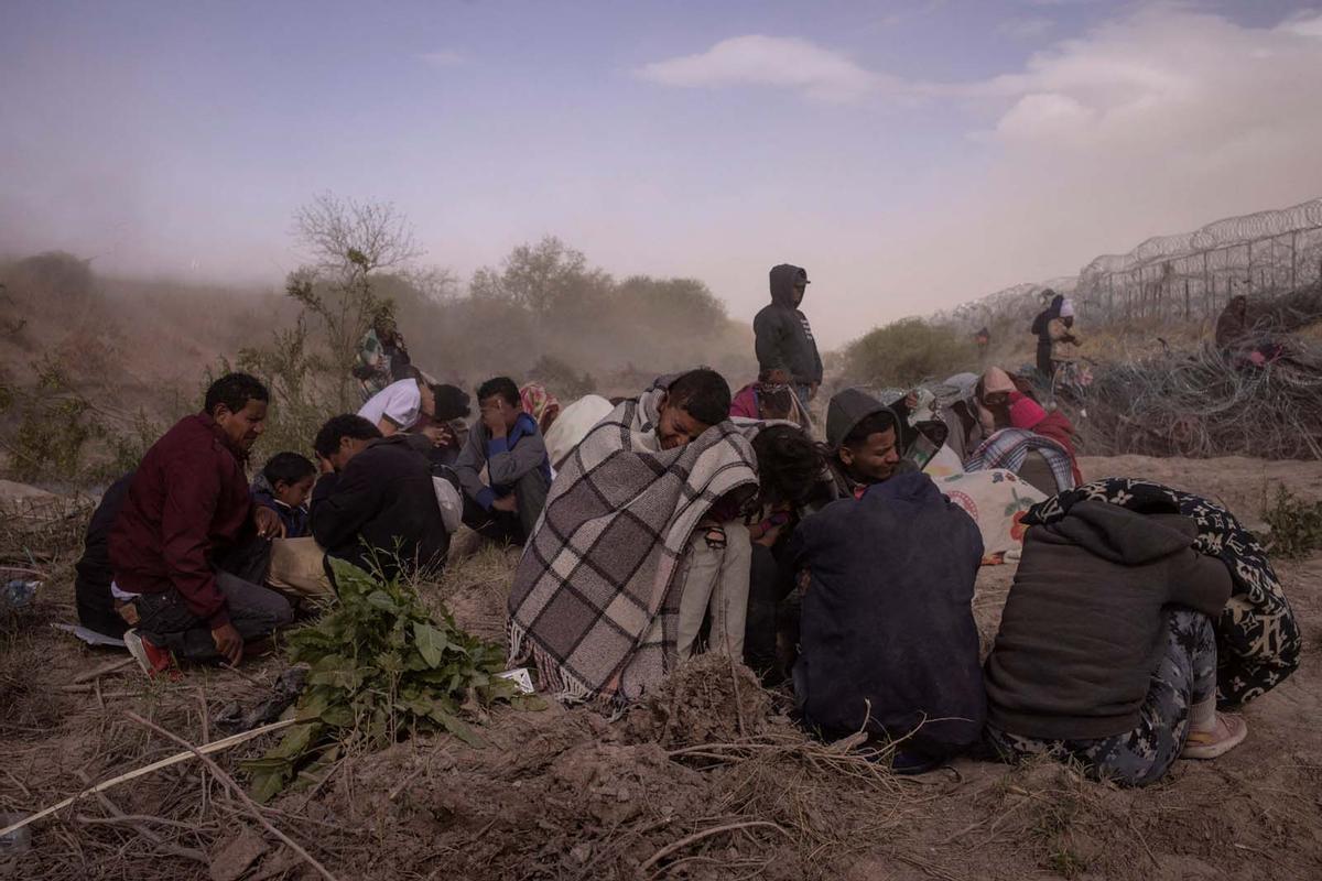 Migrantes acampan a lo largo de la orilla del río Grande mientras esperan entregarse a las autoridades de inmigración en El Paso, Texas, EE.UU