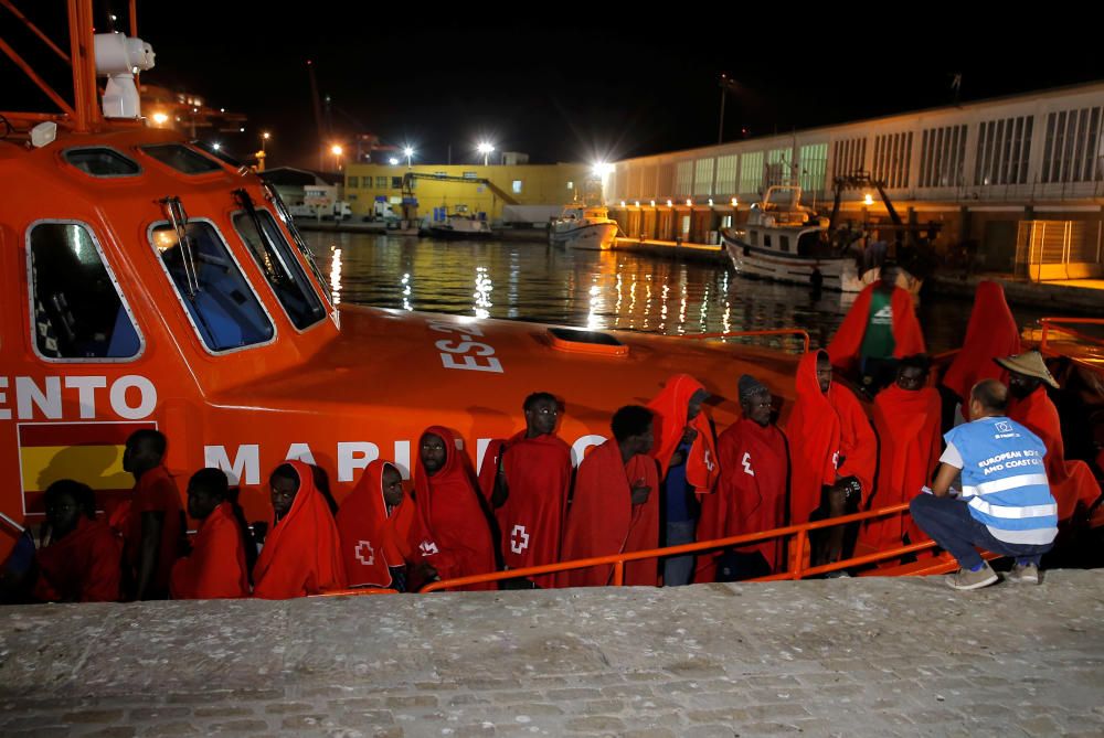 A member of Frontex talks to migrants as they ...