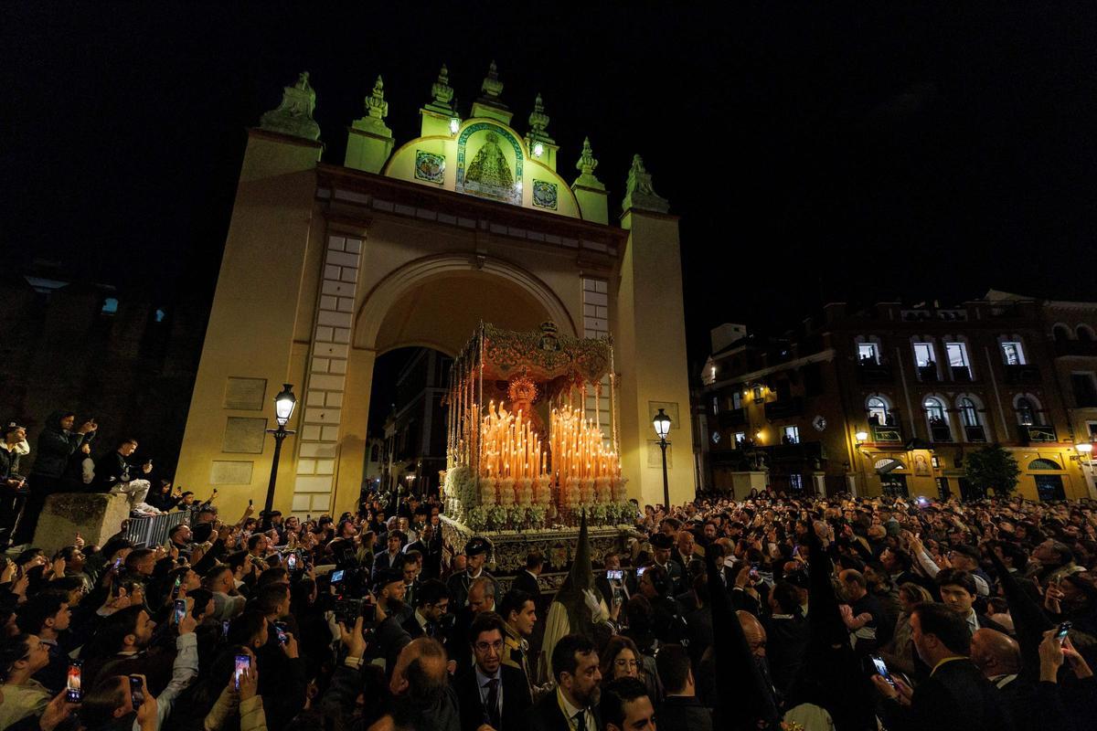 El palio de la Esperanza Macarena cruza el arco junto a su templo en su salida en la Madrugá de Sevilla.