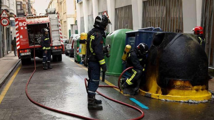 Los bomberos extinguen las llamas de un contenedor en la calle Begoña el pasado mes de marzo.