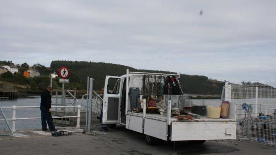 Operarios de Puertos trabajando, ayer, en la retirada de la valla del muelle naviego.