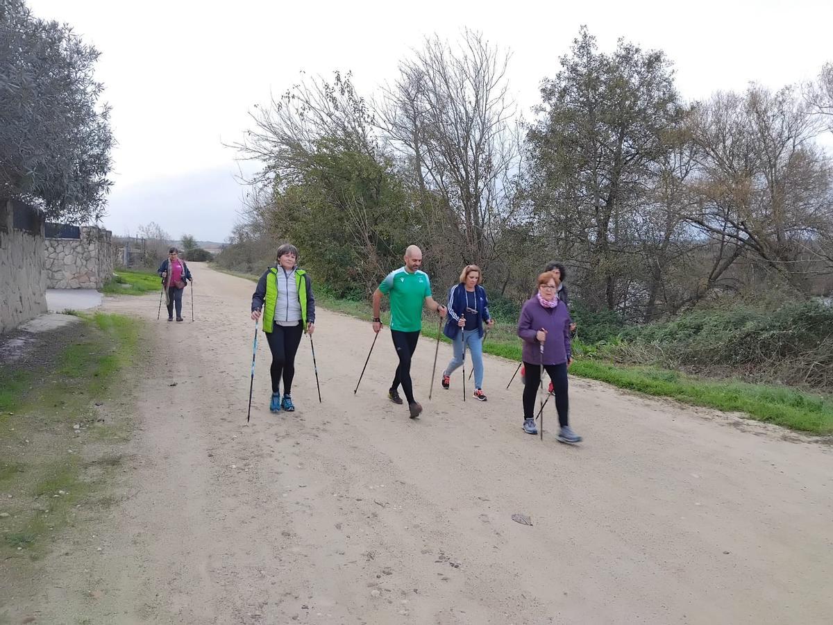 Varias personas, durante una marcha nórdica.