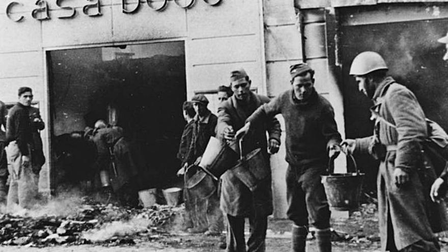 Soldats franquistes apagant l’incendi de la ganiveteria Boué, al Pont de Pedra, el 4 de febrer del 1939. | CIFRA