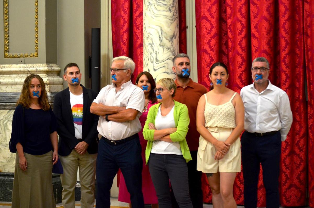 Los concejales de Compromís con un esparadrapo en la boca para denunciar los recortes democráticos de Catalá