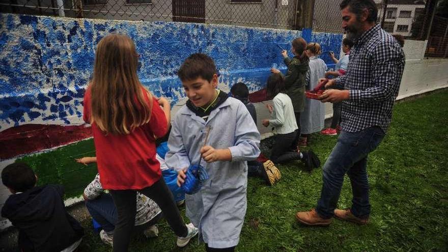 Juan Carlos Platis y los alumnos pintaron el muro del colegio. // Iñaki Abella