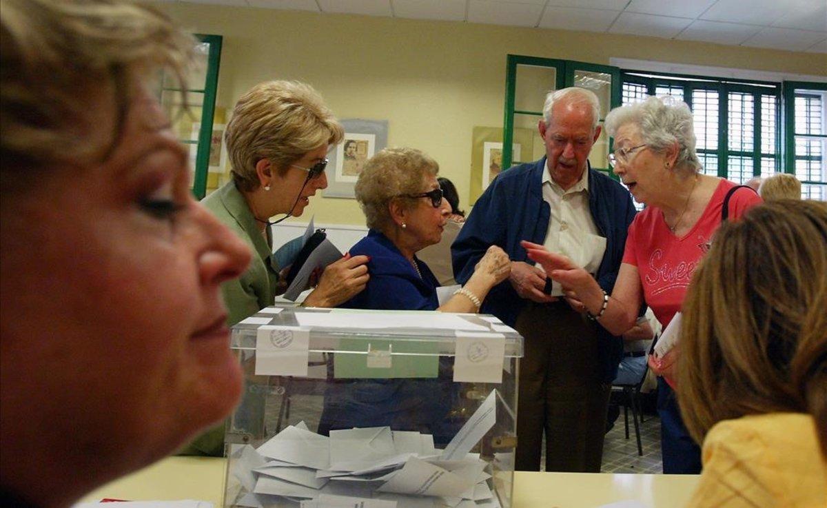 Dos mujeres conversan durante la votación en un colegio electoral de Gràcia (Barcelona).