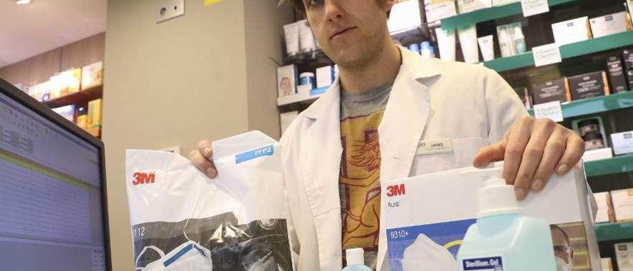 Jaime Ortega-Meder, ayer en su farmacia de Avilés, con dos paquetes de mascarillas reservadas para enviar al extranjero y geles de manos.
