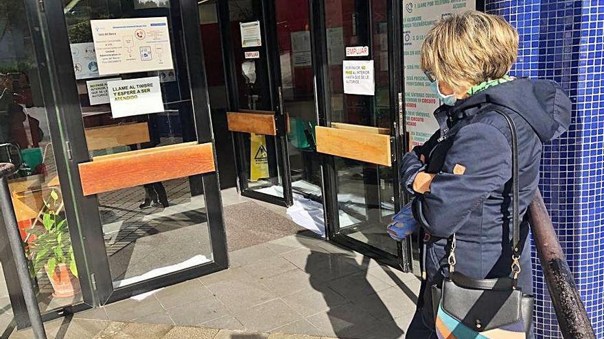 Una vecina observa las toallas a la entrada del centro de salud de Soto del Barco.