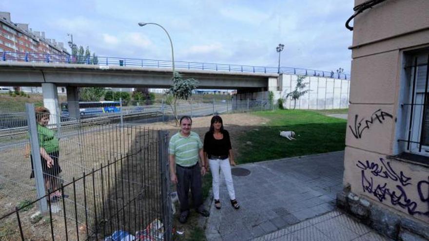 Belén González y Raúl González, entre su casa en la calle Río Navia y los terrenos por los que discurrirá el nuevo vial.