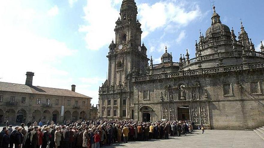 Personas aguardan a la entrada de la catedral de Santiago de Compostela / la opinión