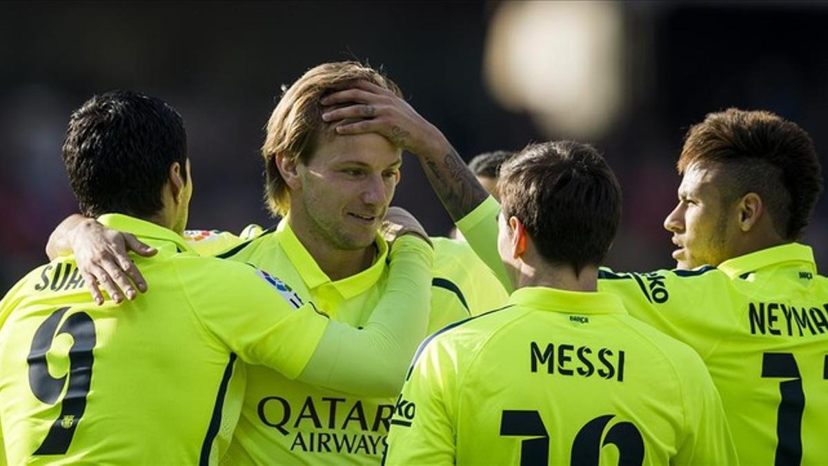 Rakitic recibe las felicitaciones de sus compañeros tras abrir el marcador en Granada.