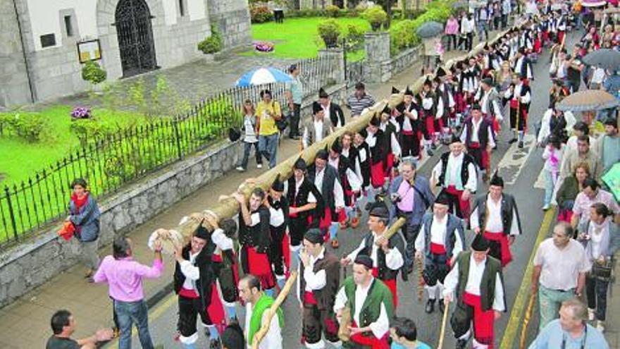 Los mozos del bando trasladan la hoguera del Cristo por las calles de Nueva.