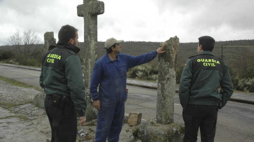 Un vecino muestra a la Guardia Civil los destrozos en el Calvario de Bercianos que habría causado el detenido en 2012.