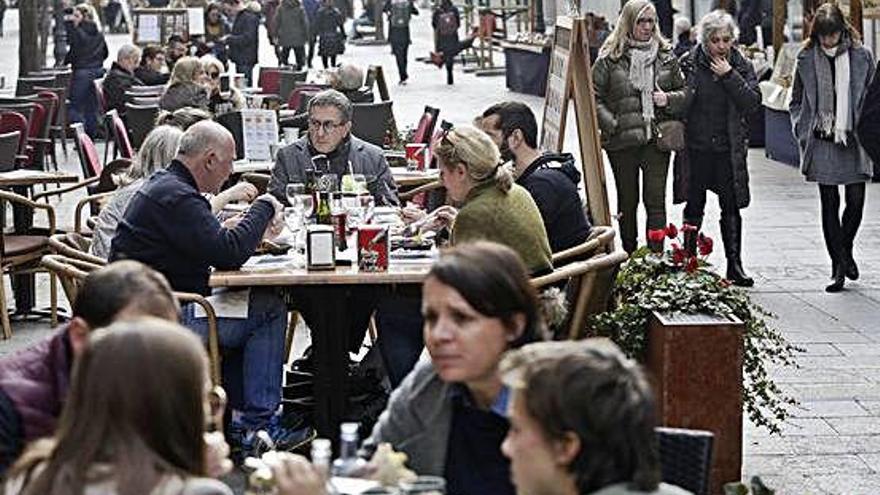 A l&#039;esquerra, gent menjant a les terrasses de la Rambla. A la dreta, la Fira d&#039;alimentació de la plaça Catalunya.