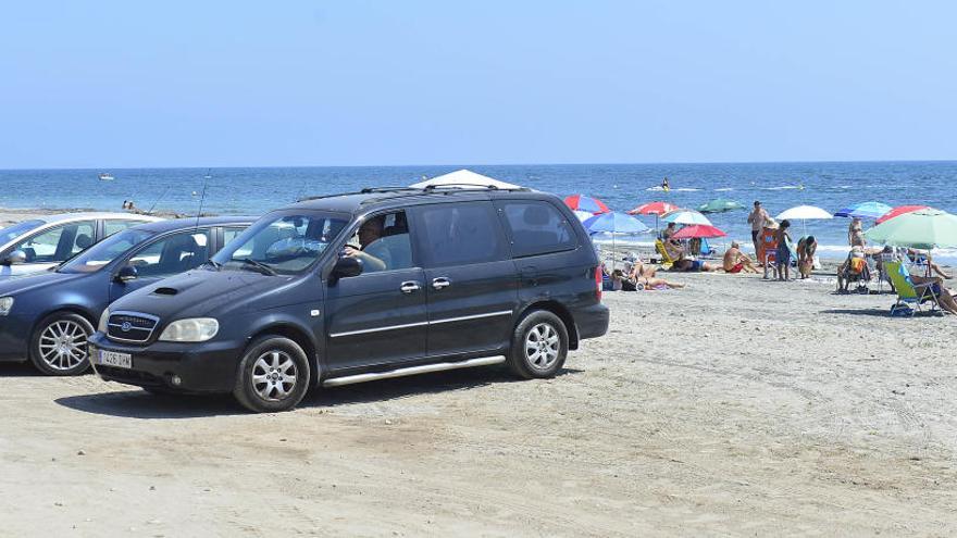 Vehículos estacionados este verano en primera línea de playa, en el camino del faro de Santa Pola.