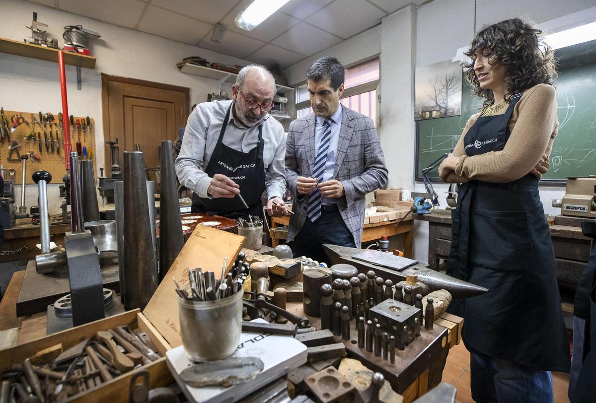 El director xeral de Comercio e Consumo, Gabriel Alén, atiende a las indicaciones de Ricardo Rivas, reconocido con el Premio Traxectoria en los Premios Artesanía de Galicia 2020 durante el curso de Técnicas de ourivería e acibechería