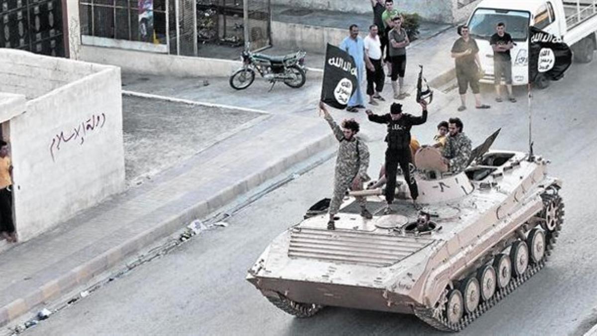 Yihadistas del Estado Islámico (EI) en un tanque por las calles de Raqqa.