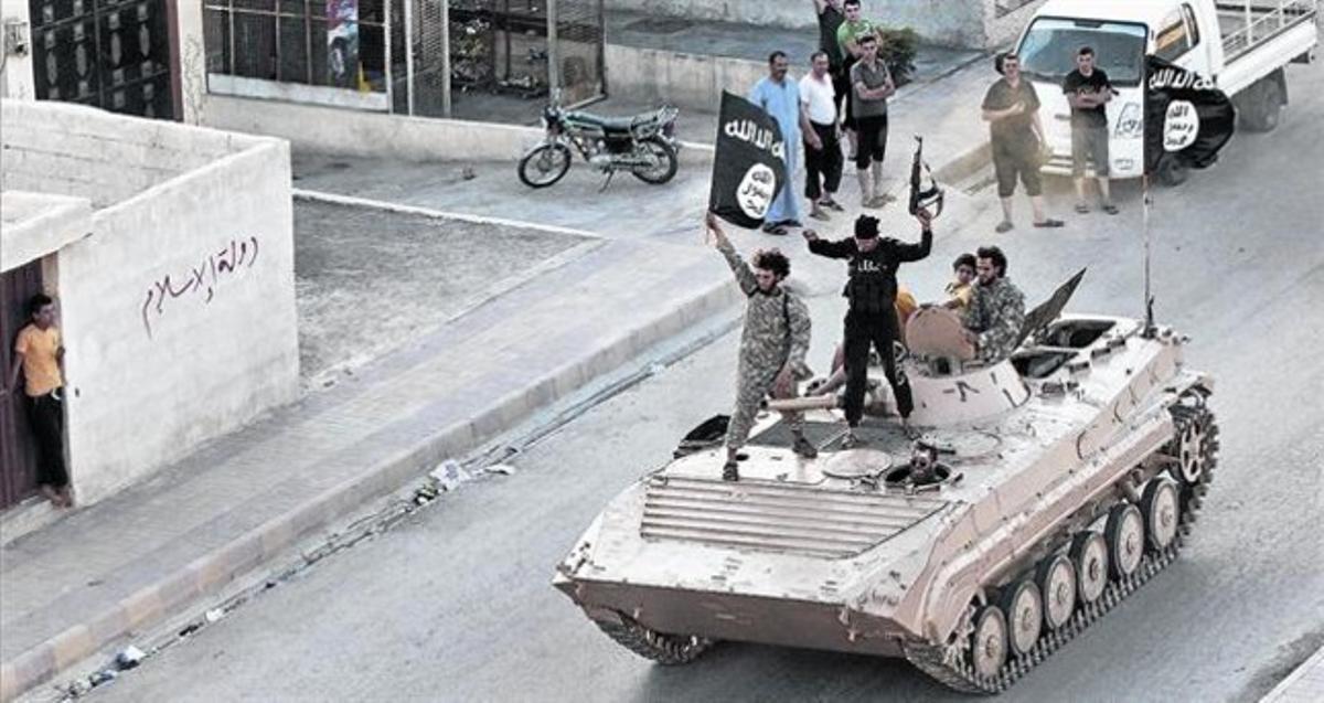 Gihadistes de l’Estat Islàmic (EI) en un tanc pels carrers de Raqqa.