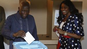 El expresidente de Angola, José Eduardo dos Santos, deposita su voto mientras su esposa Ana Paula lo observa durante las elecciones nacionales en la capital