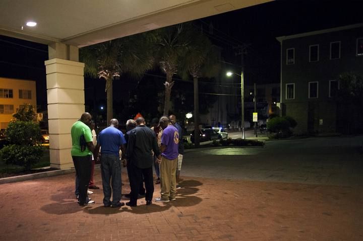 A small prayer circle forms nearby where police are responding to a shooting at the Emanuel AME Church in Charleston