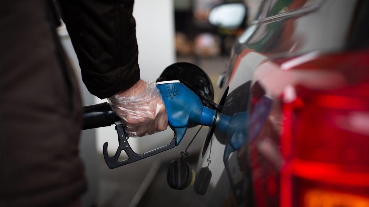 Un hombre repostando en una gasolinera.