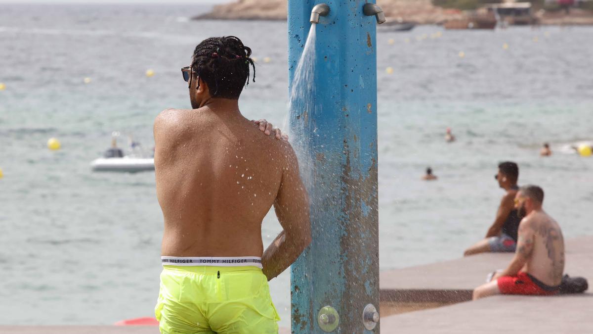 Un hombre se ducha en una playa de Ibiza en una imagen de archivo
