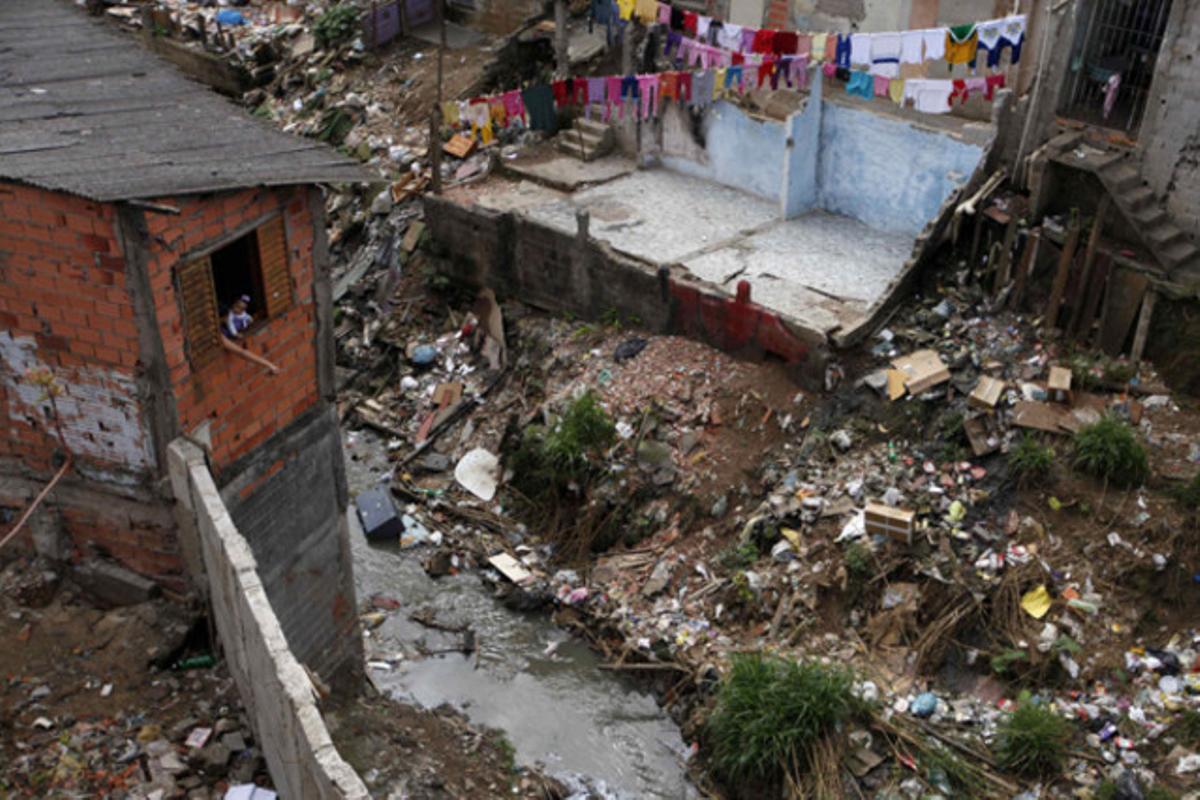 Una dona i la seva filla miren per una finestra a la favela Vila Flávia de São Paulo (Brasil).