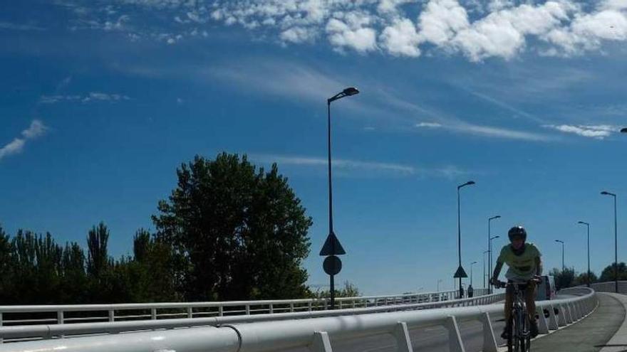 Un ciclista pasea por el puente de Los Poetas.