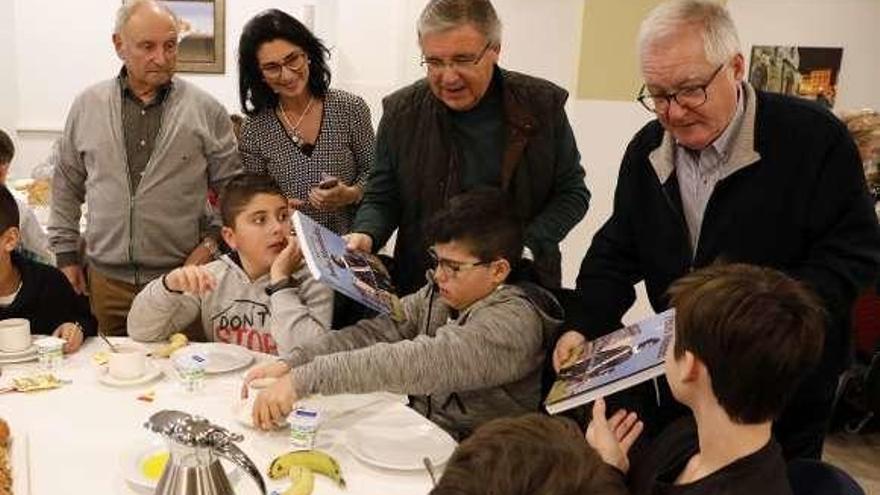 Hugo Iglesias, Antonio González e Izan García reciben el libro de manos de Román Antonio Álvarez y Sabino González, en presencia de Agustín Hidalgo y Mari Luz Pérez, en pleno desayuno cardiosaludable.