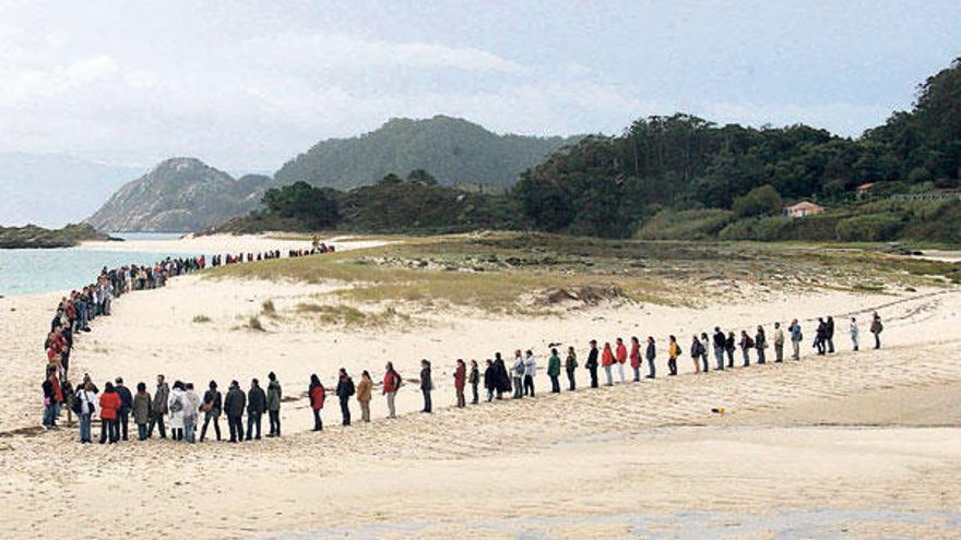 Cadena humana formada sobre la arena de Rodas para reivindicar la protección de las dunas de Cíes.